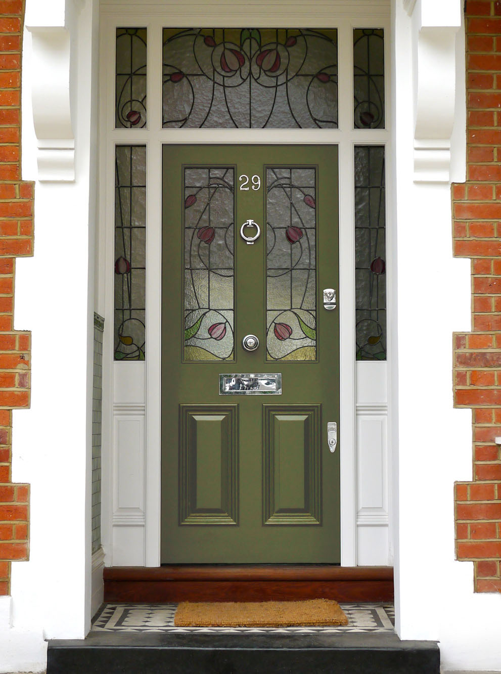 Olive green Victorian front door, with silver hardware and bespoke stained glass panels.