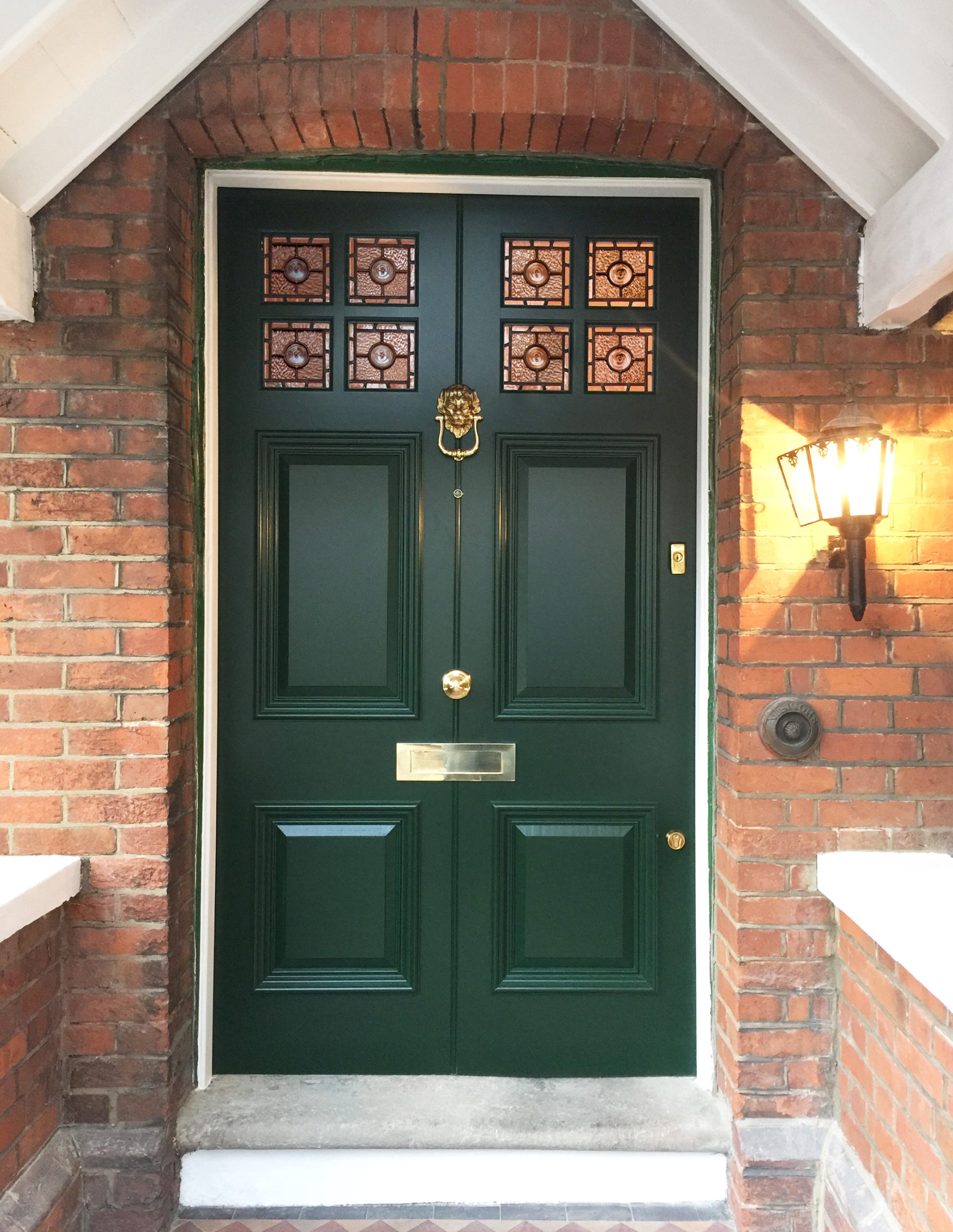 Green Victorian wooden front door with gold hardware
